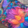 A vibrant tapestry featuring a large pink and orange lotus flower with purple and blue accents.
