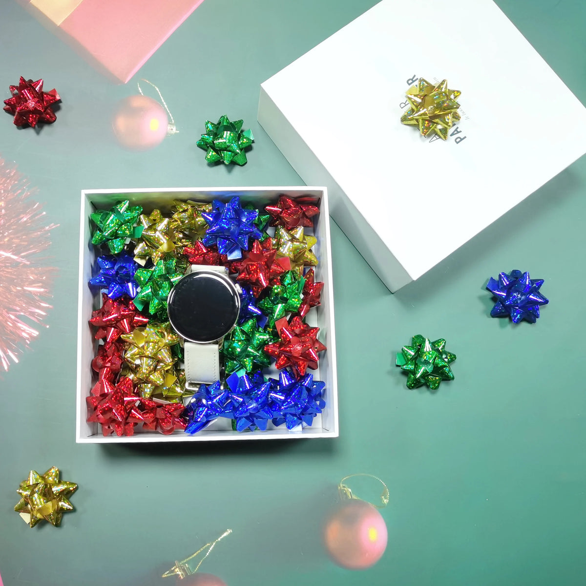 A collection of holographic star gift bows in various colors, including red, green, blue, and gold, displayed on a light gree