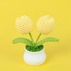 Hand woven crochet yellow flowers in a white pot on a yellow background