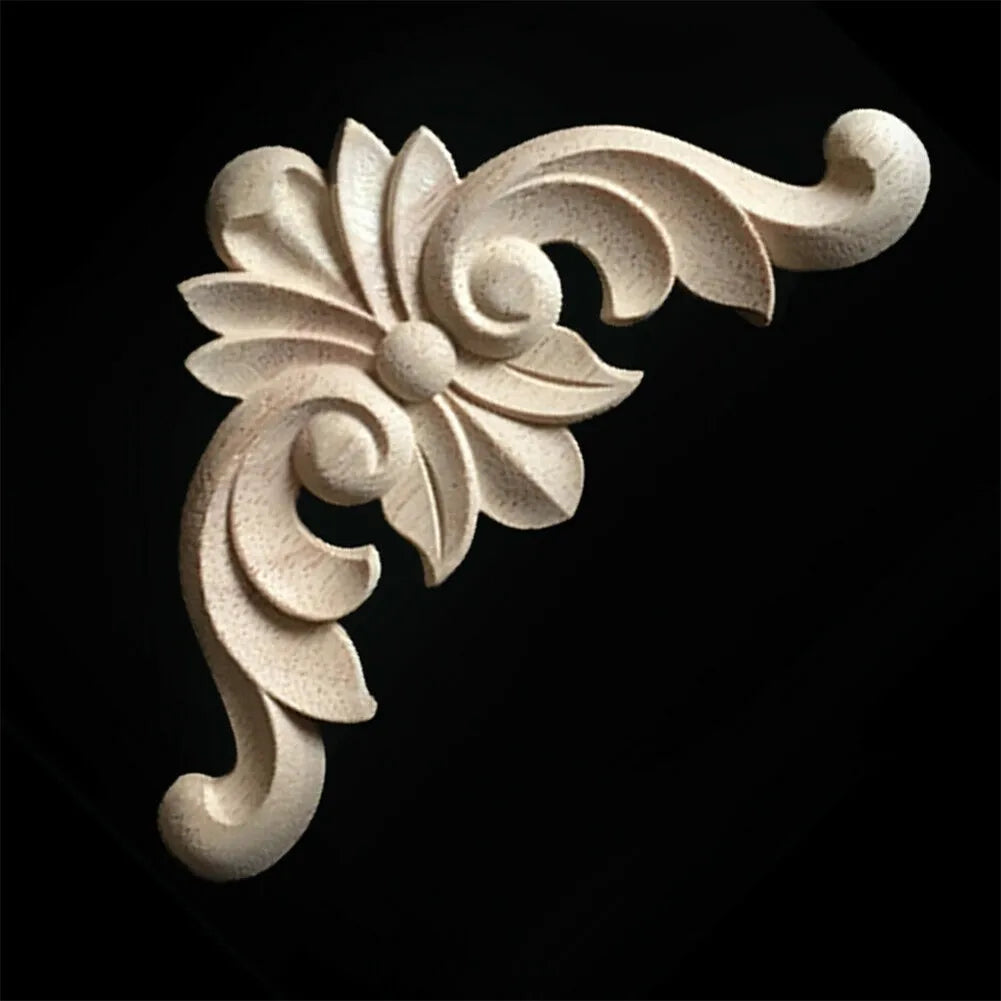 A set of four light-colored wooden carved corner appliques used for furniture and frame decoration.