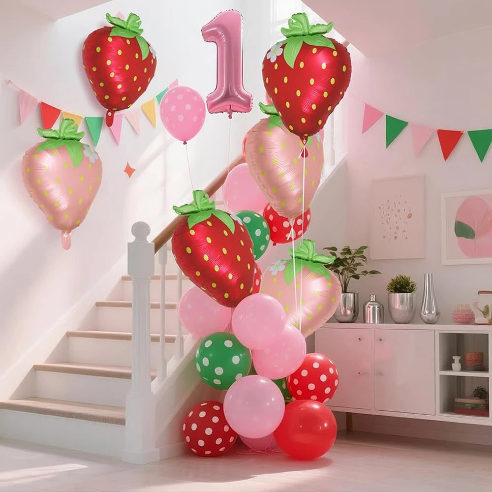 A display of red and pink strawberry foil balloons decorating a staircase with festive bunting.