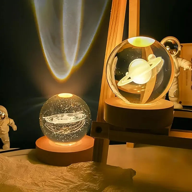 A crystal ball decoration with a glowing interior and a small astronaut figure is displayed on a wooden stand.