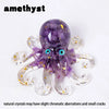 A purple amethyst crystal octopus statue with gold flecks and blue eyes