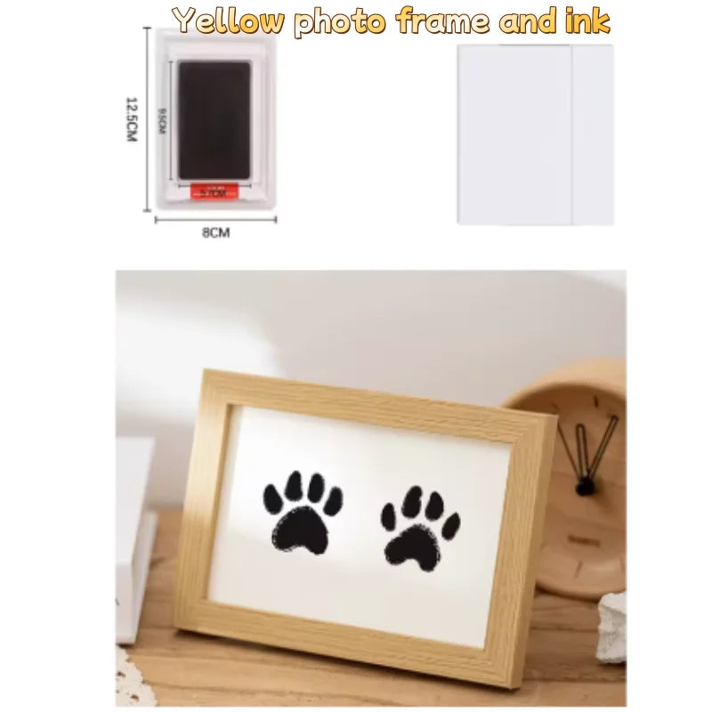 A wooden photo frame displaying black paw prints on white paper, ready for use with ink.