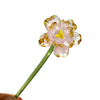 Handcrafted blue glass flower sculpture with yellow accents on a green stem