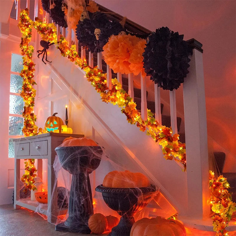 An autumn decor display featuring a staircase decorated with orange and black foliage, pumpkins, and seasonal lighting.