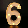 A glowing white LED alphabet night light shaped like the number six on a dark background.