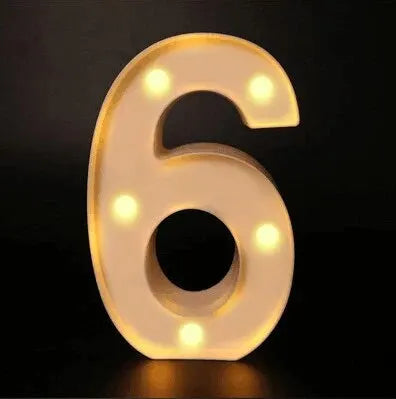 A glowing white LED alphabet night light shaped like the number six on a dark background.