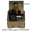 A hand-cranked wooden music box featuring an illustration of a character and a small bird.