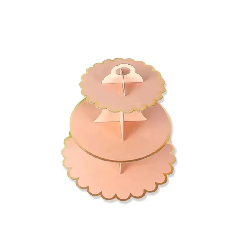 A three-tier rainbow cupcake stand made of light pink or peach colored material.