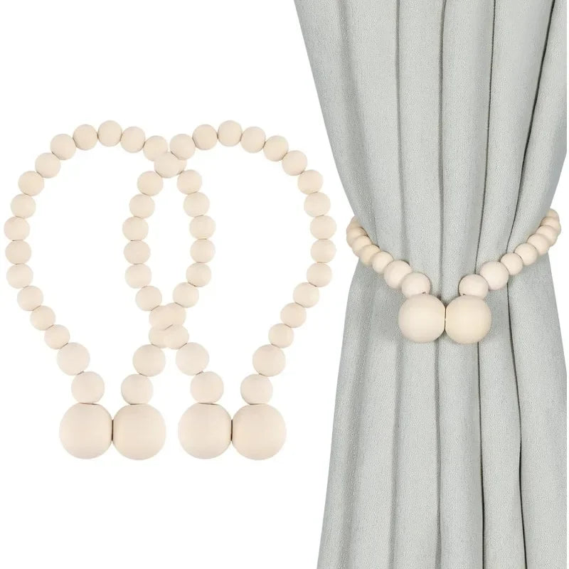 A set of two light wood magnetic bead curtain tiebacks against a gray fabric backdrop.
