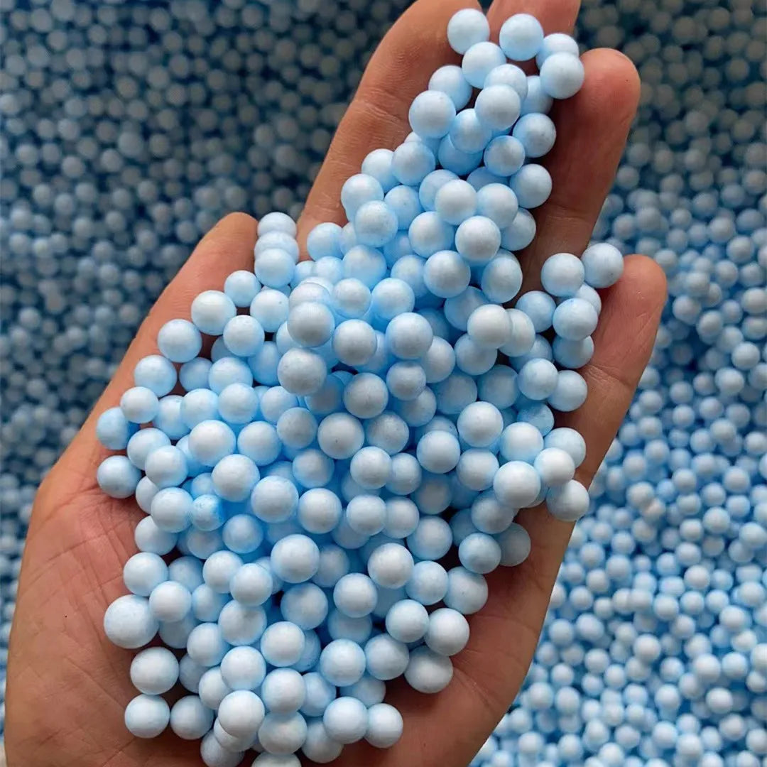 A hand holds a cluster of light blue pastel foam beads for crafting and decoration.