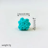 A set of three small, bright turquoise foam cake toppers shaped like a whale, octopus, and turtle.