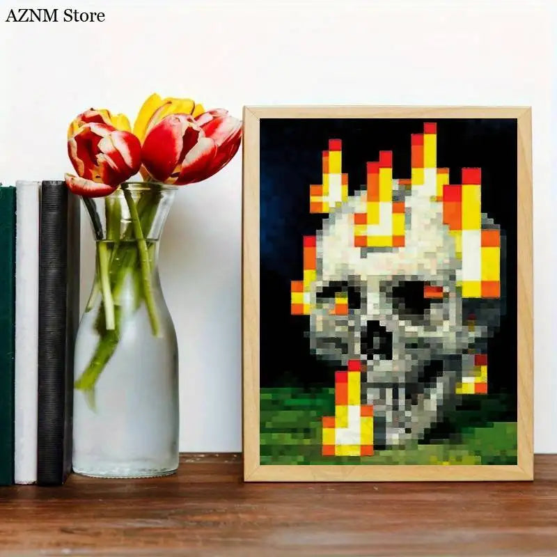 An unframed art print featuring a pixelated skull with flames on a dark background, displayed next to a vase of red tulips.