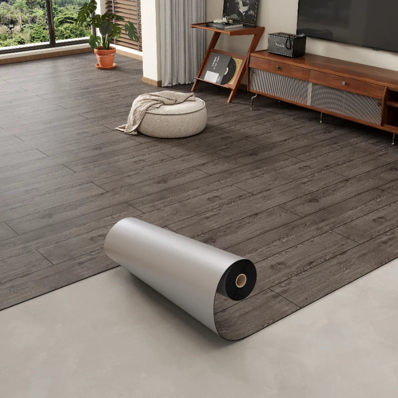 Roll of 3D textured wood grain self-adhesive flooring film laid on a light floor.