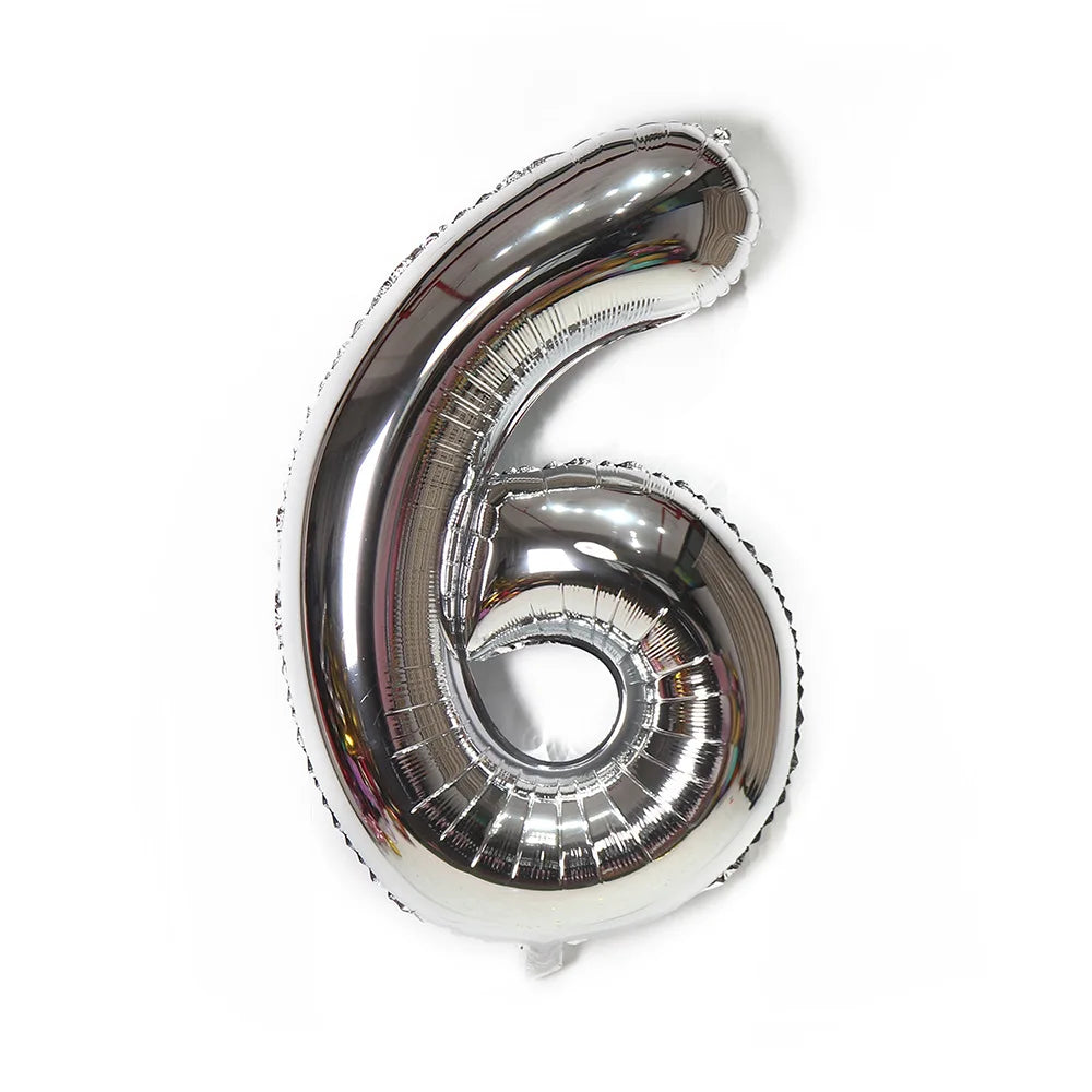 A metallic silver foil balloon shaped like the number six.