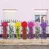 A row of vibrant artificial flowers in various colors, including pink, white, yellow, red, and purple, displayed in tall hang
