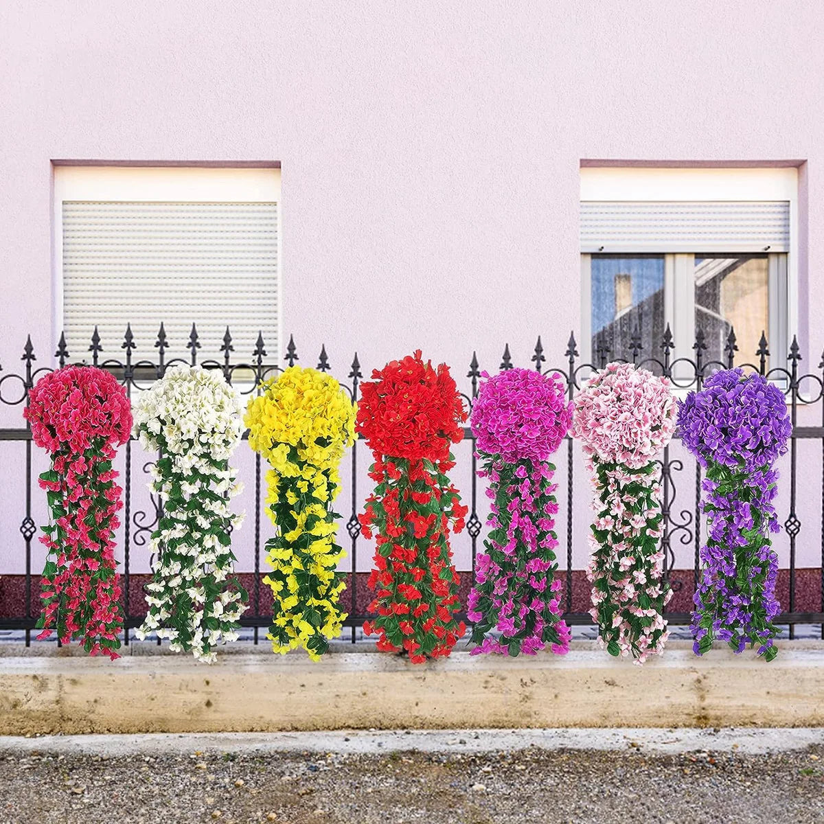 A row of vibrant artificial flowers in various colors, including pink, white, yellow, red, and purple, displayed in tall hang