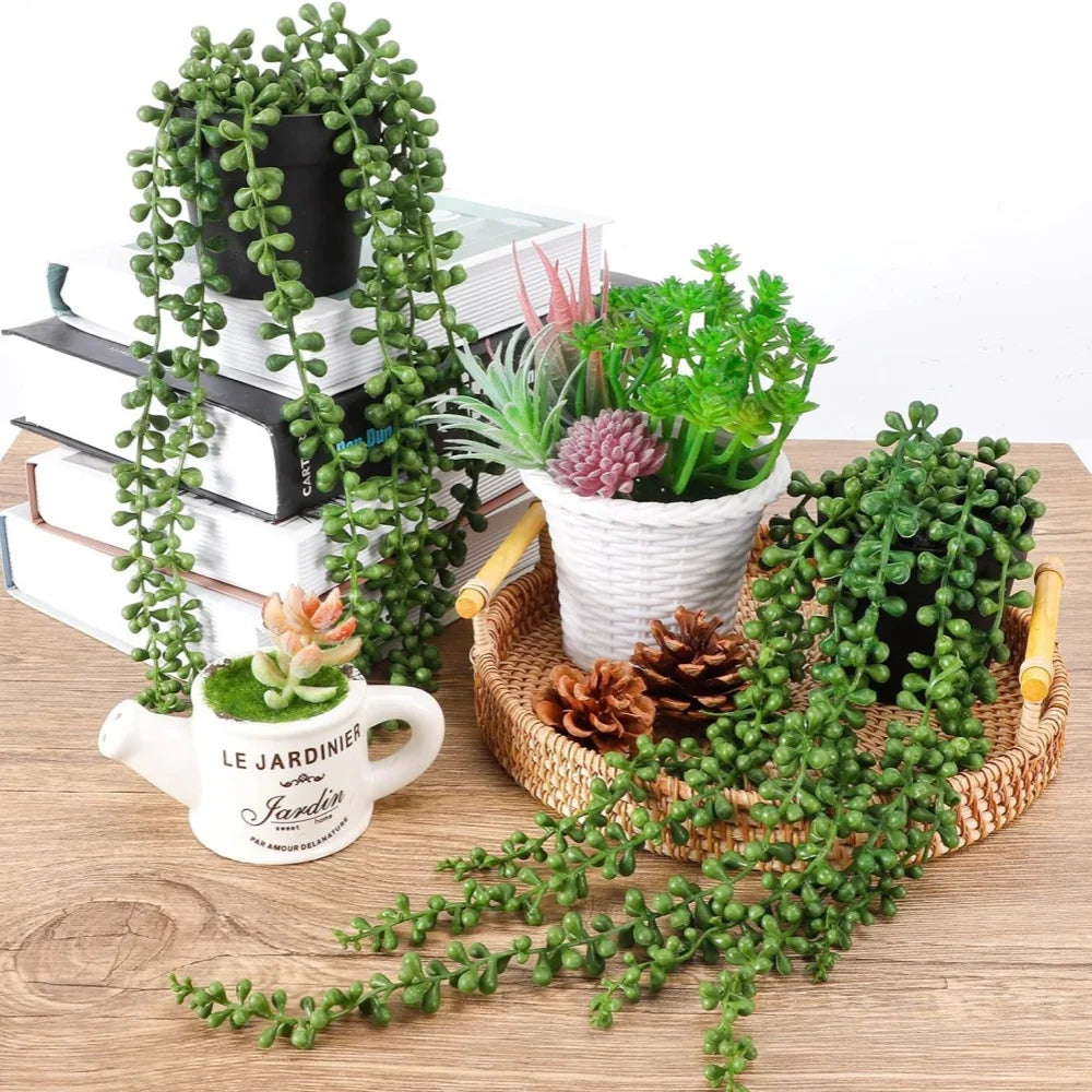 Hanging artificial plant wall decor featuring green foliage and succulents displayed on a wooden surface.