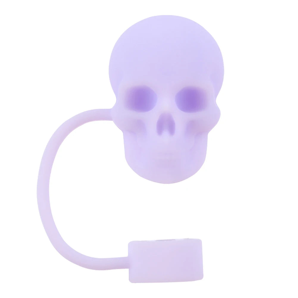 A purple reusable silicone straw cover shaped like a skull with a loop for attachment.