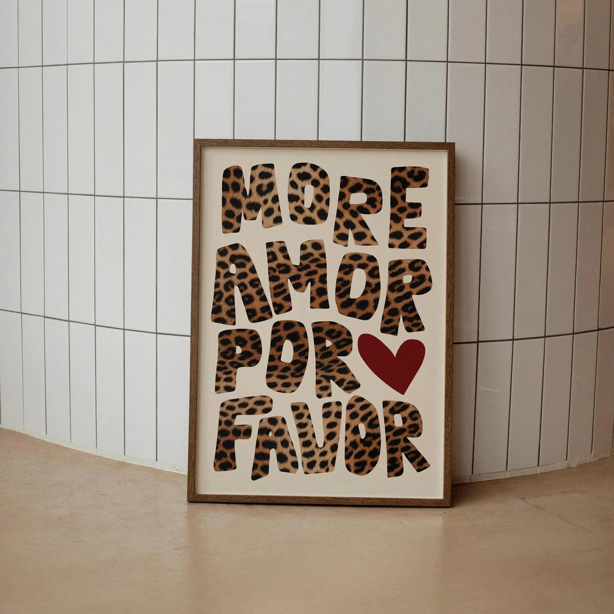 A framed canvas print featuring the text More Amor Por Favor in a leopard print font with a red heart symbol.