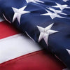 Close-up of a heavy duty embroidered American flag banner showing blue and white stars on fabric.