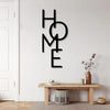 Black metal word art spelling out HOME mounted on a white wall above a wooden table.