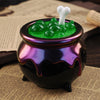 A dark purple glass jar filled with green silicone mold material topped by a white, tooth-shaped silicone piece.