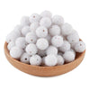 A pile of white textured resin beads for jewelry making in a wooden bowl.