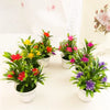 A collection of artificial lotus flowers in various colors like red, yellow, and pink potted on a white surface.