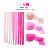 Ein Set aus rosa und weißem Crêpepapier-Girlanden, Rollen und Streifen, zum Dekorieren.