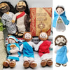 A collection of religious plush dolls depicting Jesus and the Virgin Mary, including a large depiction with a Bible and small