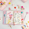 A pink luxury heart pendant diary set with planner pages and decorative accessories is displayed on a white surface.