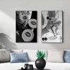Black and white art print featuring high heels on a canvas against a dark background.