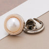 A close-up of a pearl and rhinestone no-sew brooch button with a gold-toned setting.