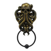 A bronze octopus skull door knocker featuring intricate detail and a cast iron ring.