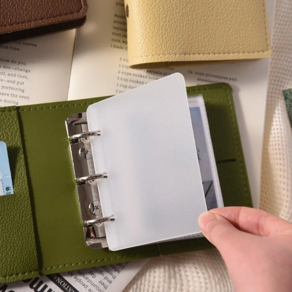 A close-up of a lime green faux leather photo album with a clear plastic cover and a white page inside.