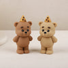 A pair of cute, round brown teddy bear cake toppers with gold pyramid accents.