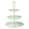 A three-tier plastic cupcake stand with a gold-toned metal topper and light mint green plates.