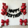 A decorative banner made of black heart balloons spelling out HAPPY BIRTHDAY with red balloons and bow accents.