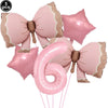 A set of pink bow disposable party tableware, including a large number six balloon and several star-shaped balloons.