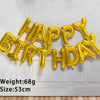 A golden foil letter birthday balloon set spelling out HAPPY BIRTHDAY hanging on a white wall.