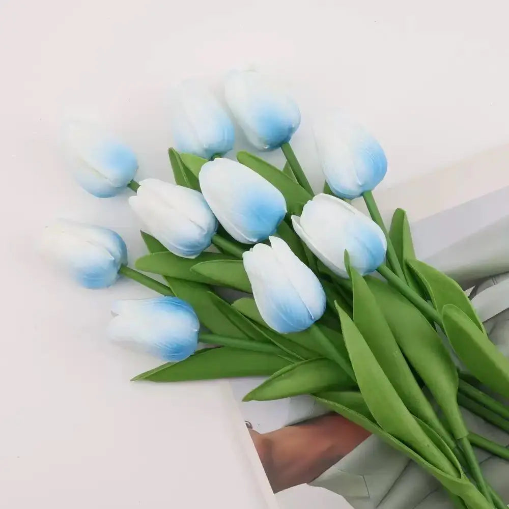 A bouquet of realistic artificial blue and white tulips with green stems.