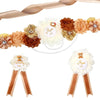 A set of floral maternity sash and corsage pins featuring peach, brown, and cream flowers with gold accents.