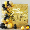 A gold glitter mosaic wall backdrop decorated with balloons and the words Happy Birthday