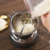 A hand pours white soy wax flakes into a metal pot for DIY candle making.