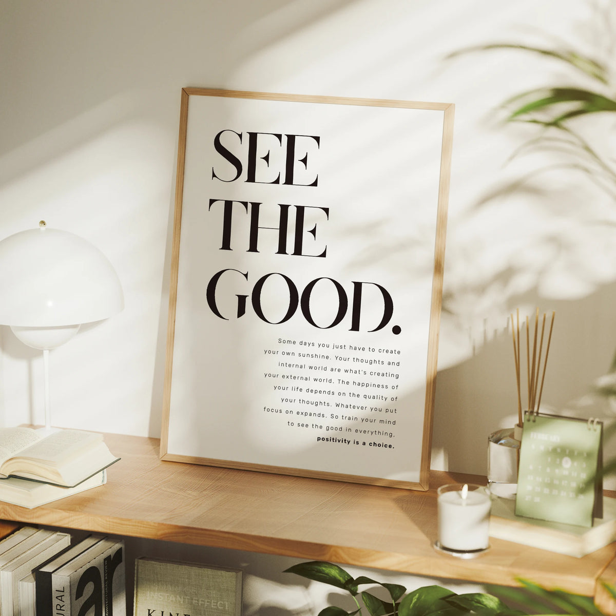 A framed inspirational quote canvas wall art poster with black text on a light background displayed on a wooden surface.