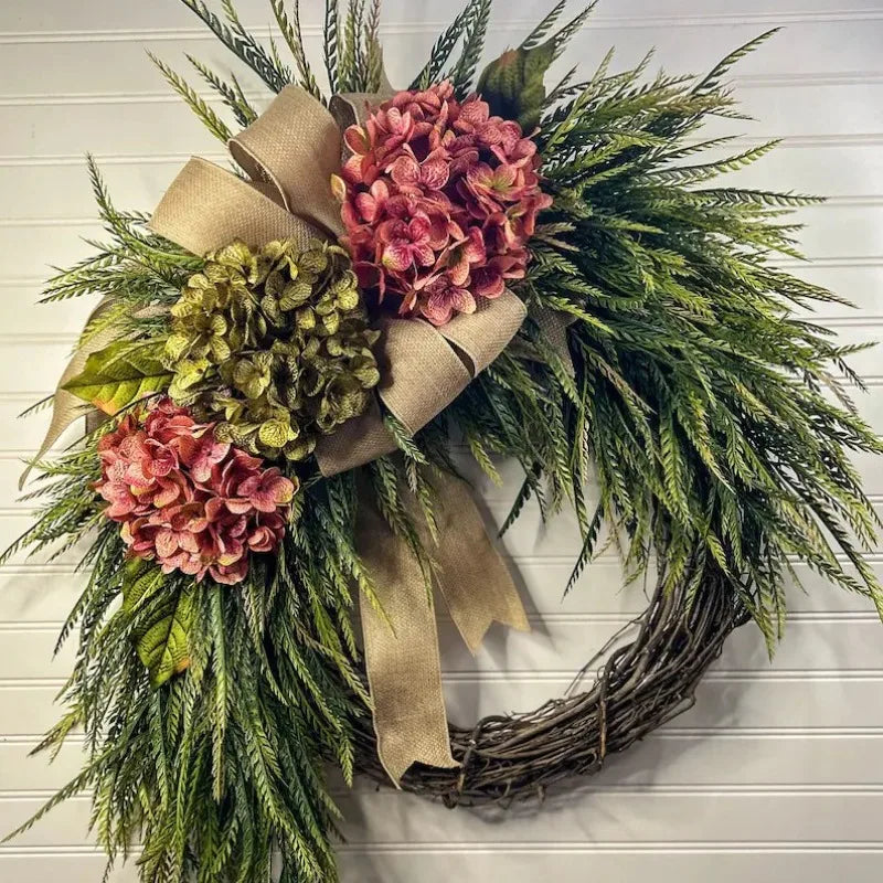 Rustic hydrangea wreath with pink and green foliage tied with a burlap bow for door or wall decor