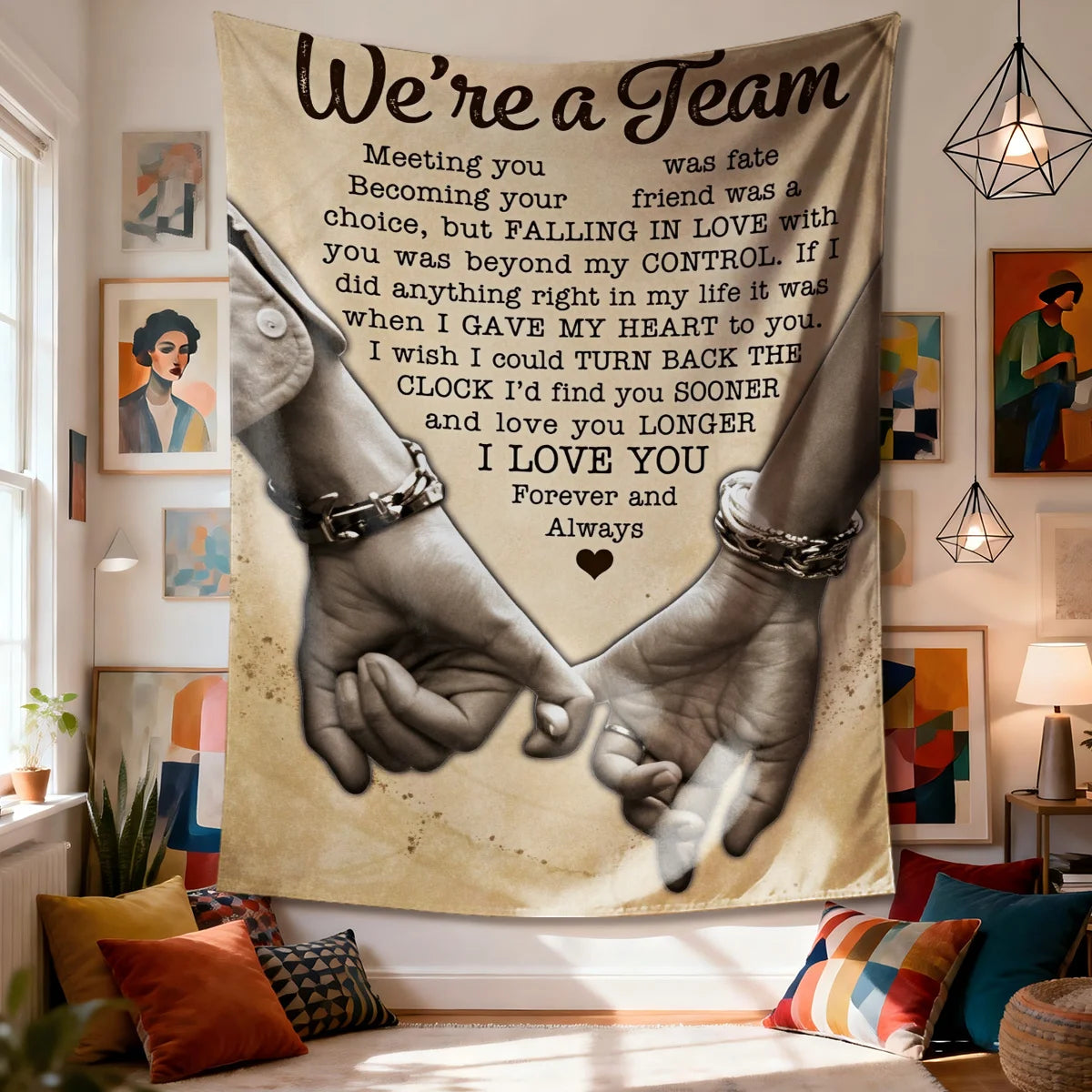 A fabric wall tapestry featuring a black and white illustration of two hands clasped together with the text We're a Team.