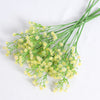 A bunch of artificial baby's breath flowers in a light yellow-green color.